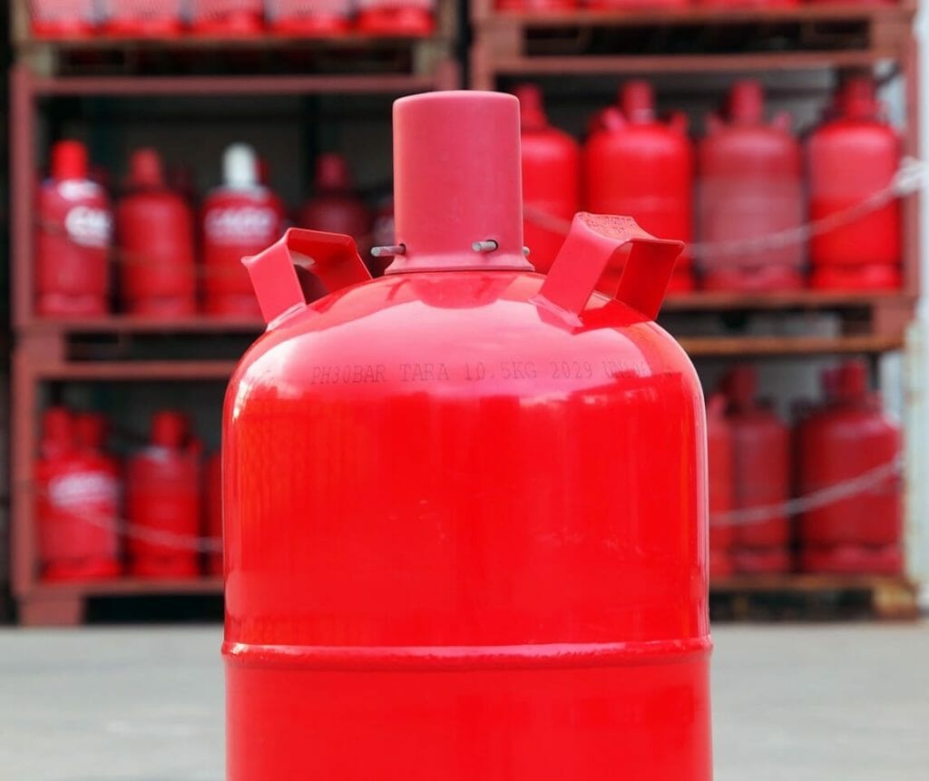 Rote Propangasflasche vor Gasflaschenlager