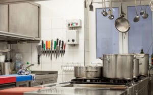 Gastro Gasherd in Restaurantküche mit angeschlossenen Gasflaschen, Töpfen und Pfannen