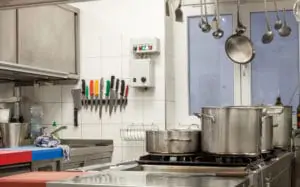Gastro Gasherd in Restaurantküche mit angeschlossenen Gasflaschen, Töpfen und Pfannen