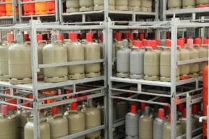 Gasflaschen lagern in Gitterboxen auf einem Betriebshof eines Gasflaschenservice