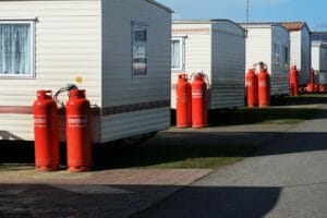 Stationäre Wohnmobile mit roten Gasflaschen in Zweiflaschenanlagen zur Gasversorgung