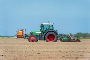 großer Unkrautbrenner an Traktor mit mobilem Gastank auf einem Feld beim Kartoffelkraut brennen