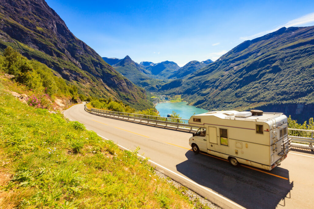 Wohnmobil in der Sonne auf einer Straße neben dem Geirangerfjord 