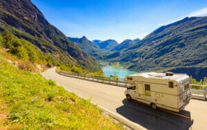 Wohnmobil in der Sonne auf einer Straße neben dem Geirangerfjord